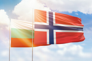 Sunny blue sky and flags of norway and bulgaria