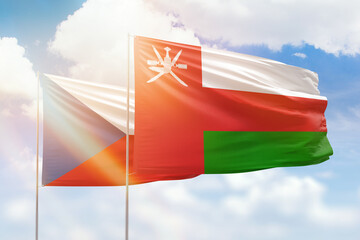 Sunny blue sky and flags of oman and czechia