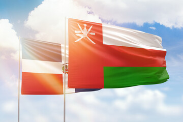 Sunny blue sky and flags of oman and dominican republic