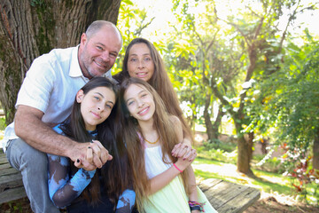 Family Enjoying a Summer Day at the Park. Beautiful Family Smiling in a Classic Outdoors Portrait.