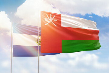Sunny blue sky and flags of oman and el salvador