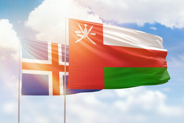 Sunny blue sky and flags of oman and iceland