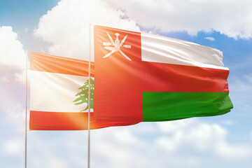 Sunny blue sky and flags of oman and lebanon