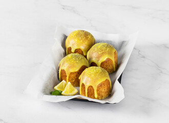 Little Lemon cakes with icing sugar, on a serving plate. Light background