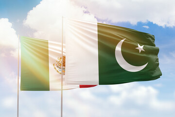 Sunny blue sky and flags of pakistan and mexico