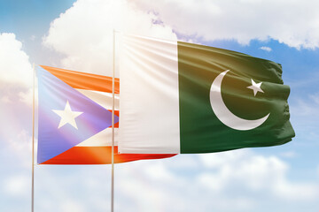 Sunny blue sky and flags of pakistan and puerto rico