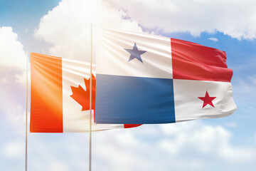 Sunny blue sky and flags of panama and canada