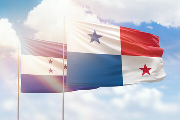 Sunny blue sky and flags of panama and honduras