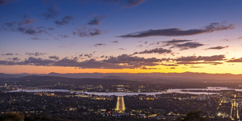 Canberra Australia viewed from Mount Ainslie at sunset looking down on the Australian War Memorial and ANZAC Parade towards Lake Burley Griffin with Parliament House behind and the suburbs of Canberra
