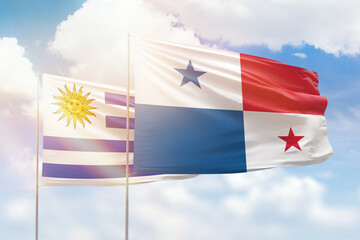 Sunny blue sky and flags of panama and uruguay