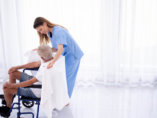 Obraz premium Doctor nurse female woman health care treatment elderly senior male man wheelchair caregiver help support handicap hospital clinic nursing home retirement happy smile indoor medical physician 