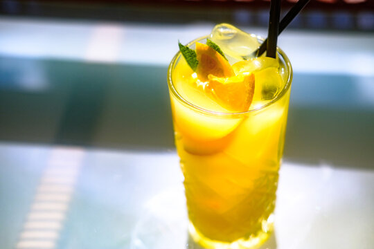 Fresh ice cold orange maraquia lemonade dressed with mint and orange slices in a glass under sunlight