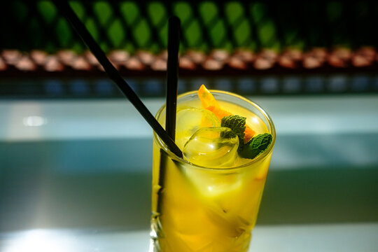 Fresh ice cold orange maraquia lemonade dressed with mint and orange slices in a glass under sunlight