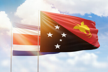Sunny blue sky and flags of papua new guinea and costa rica