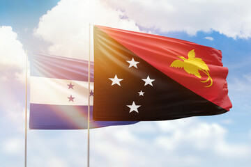 Sunny blue sky and flags of papua new guinea and honduras
