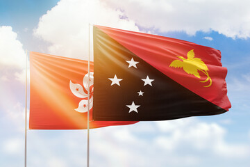 Sunny blue sky and flags of papua new guinea and hong kong