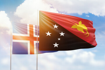 Sunny blue sky and flags of papua new guinea and iceland
