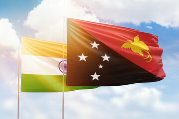 Sunny blue sky and flags of papua new guinea and india