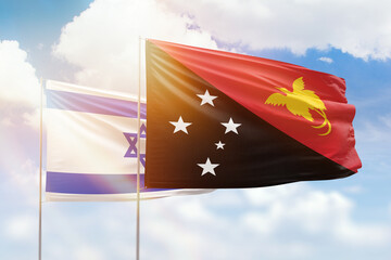 Sunny blue sky and flags of papua new guinea and israel