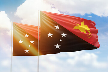 Sunny blue sky and flags of papua new guinea and papua new guinea