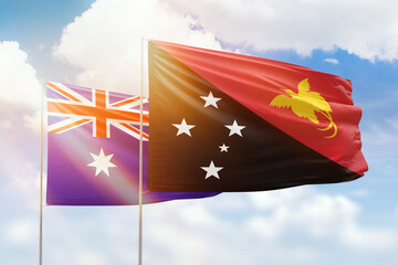 Sunny blue sky and flags of papua new guinea and australia