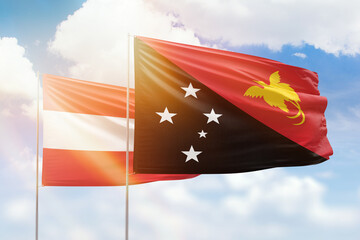 Sunny blue sky and flags of papua new guinea and austria