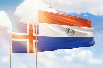 Sunny blue sky and flags of paraguay and iceland