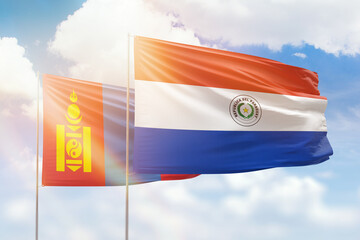Sunny blue sky and flags of paraguay and mongolia