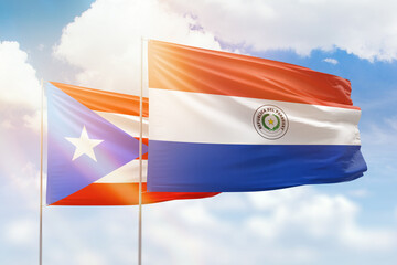 Sunny blue sky and flags of paraguay and puerto rico