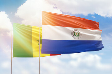 Sunny blue sky and flags of paraguay and senegal