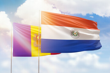 Sunny blue sky and flags of paraguay and andorra