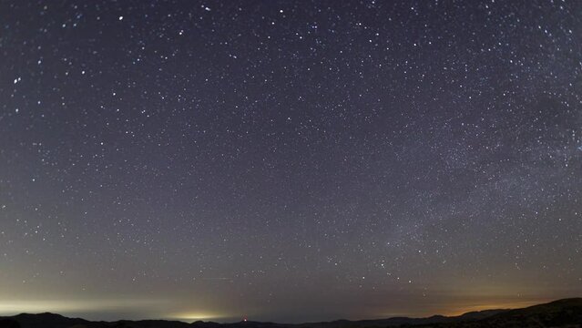Time lapse of star trails over desert landscape in California, USA