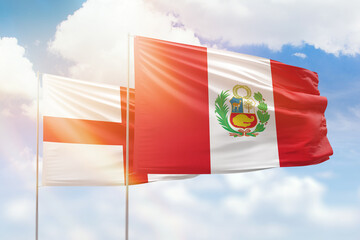 Sunny blue sky and flags of peru and england