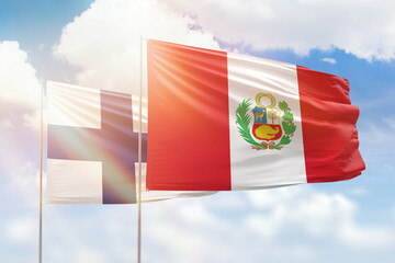 Sunny blue sky and flags of peru and finland