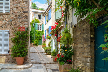 Colorful red flowers and potted plants line the narrow streets of the Old Town area of the medieval village of Grimaud, France, in the hills above Saint-Tropez on the Cote d'Azur.