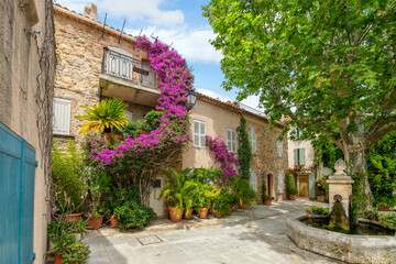 Colorful purple bougainvillea flowers line the narrow streets of the Old Town area of the medieval...
