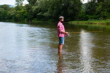 Fototapeta na wymiar Fishing hobby and summer weekend. Bearded men fisher with fishing rod and net.