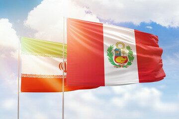 Sunny blue sky and flags of peru and iran