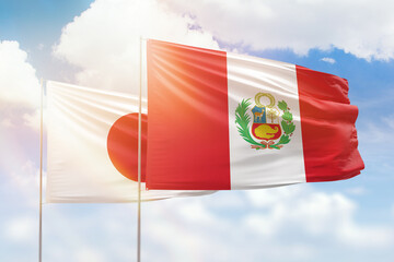 Sunny blue sky and flags of peru and japan
