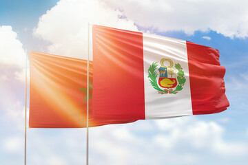 Sunny blue sky and flags of peru and morocco
