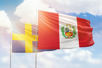 Sunny blue sky and flags of peru and sweden