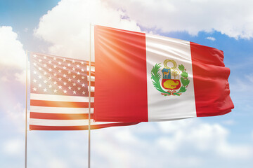 Sunny blue sky and flags of peru and usa