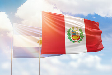 Sunny blue sky and flags of peru and argentina