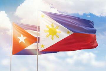 Sunny blue sky and flags of philippines and cuba