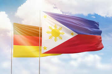 Sunny blue sky and flags of philippines and germany