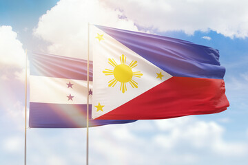 Sunny blue sky and flags of philippines and honduras