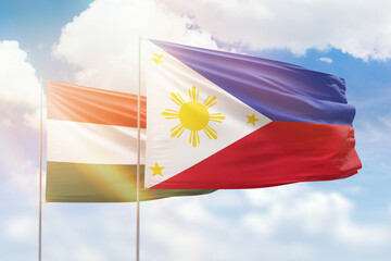 Sunny blue sky and flags of philippines and hungary