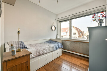 A spacious bright room with a bed, a bedside table and a wonderful view from the panoramic window