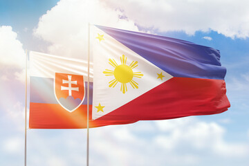 Sunny blue sky and flags of philippines and slovakia