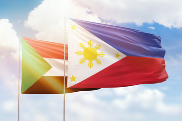 Sunny blue sky and flags of philippines and sudan